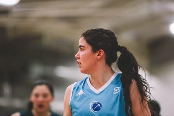 Female basketball player in blue jersey during game action.