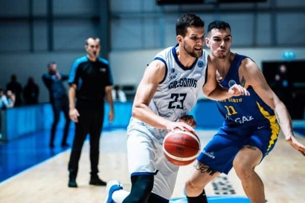 Two basketball players competing fiercely during a game at Caledonia Gladiators' home court.