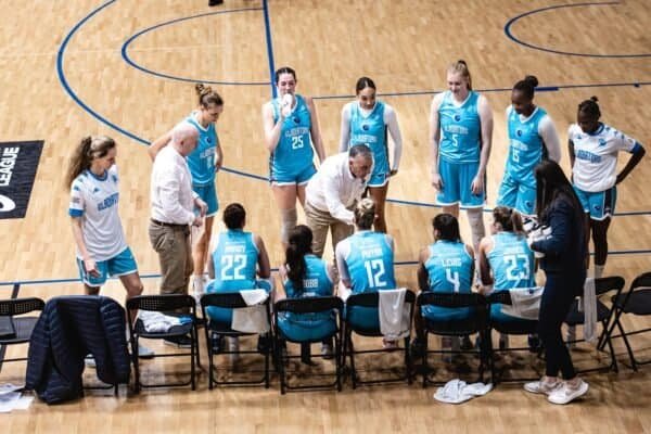 Caledonia Gladiators basketball team during timeout on court.
